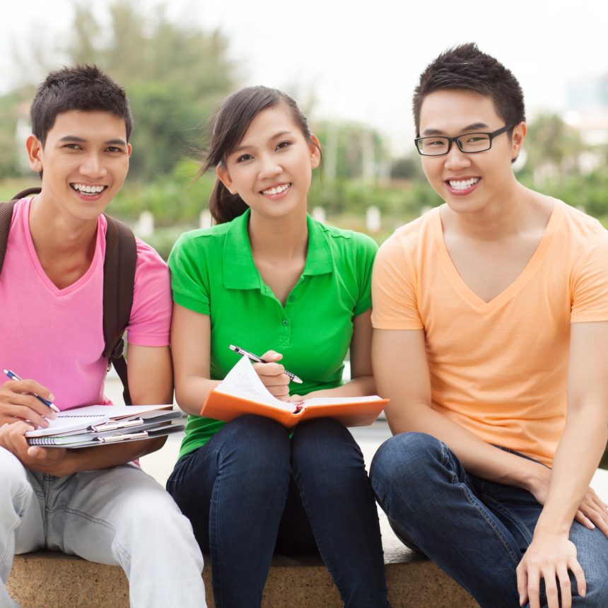 Portrait of three students sitting outdoors in break